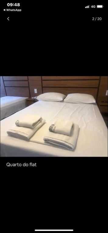 Una foto de una cama con dos toallas encima. en Flat araras luxo, en Caldas Novas