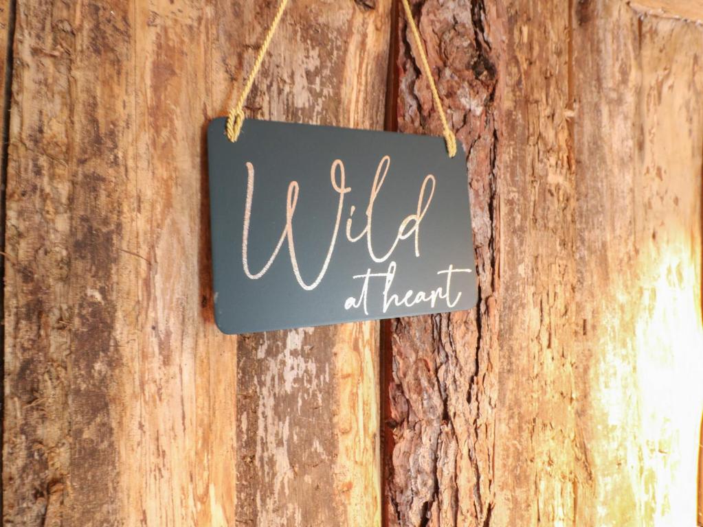 a sign that reads wild than hanging on a wooden wall at The Lazy Squire by The Water in Rugeley