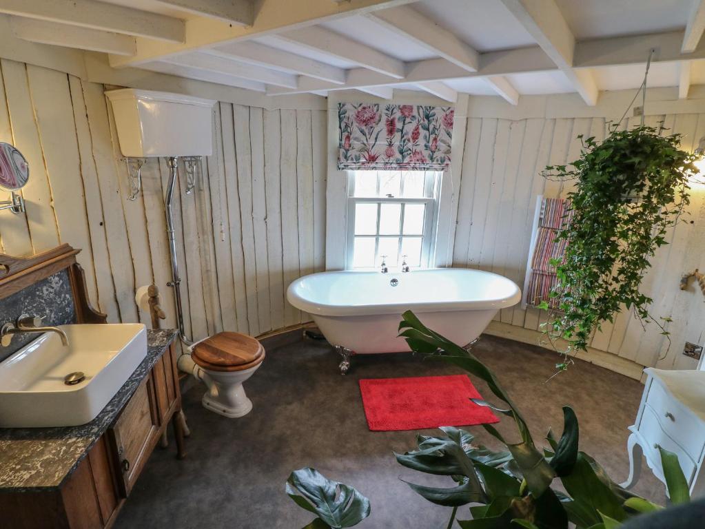 a bathroom with a tub and a toilet and a sink at The Lazy Squire by The Water in Rugeley