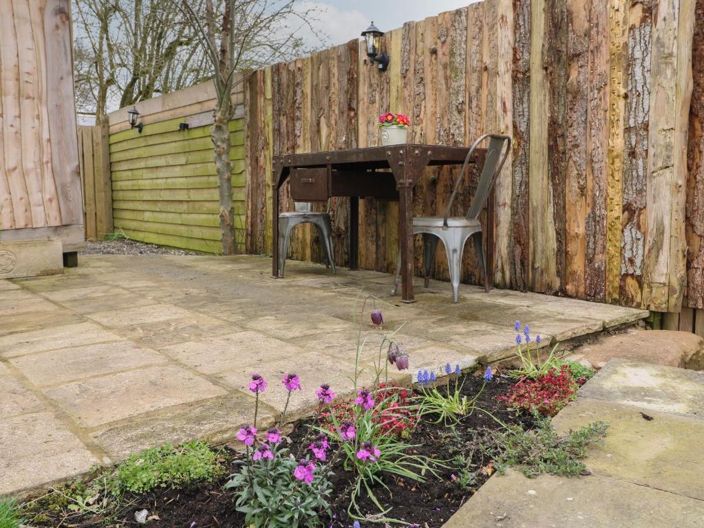 a piano sitting next to a fence with flowers at The Lazy Squire by The Water in Rugeley