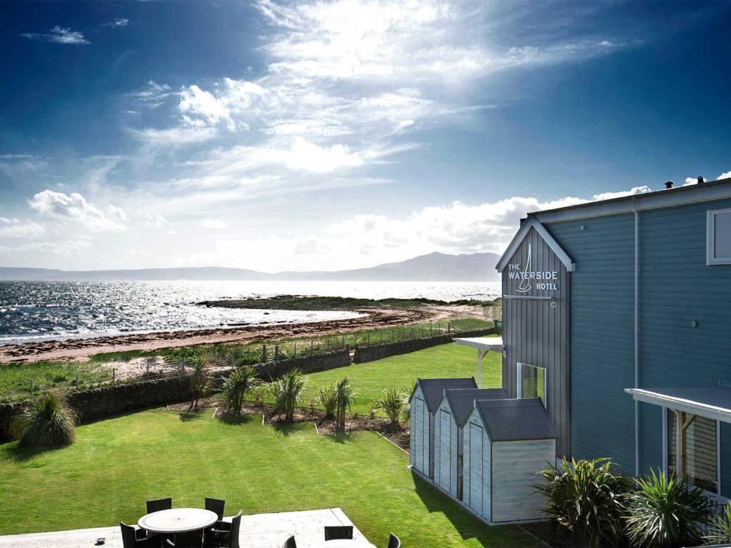 uma casa azul com vista para o oceano em The Waterside Hotel em Seamill