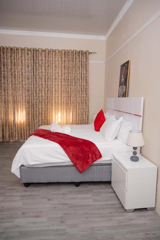 a bedroom with a large bed with a red blanket at 40 on King BnB in East London