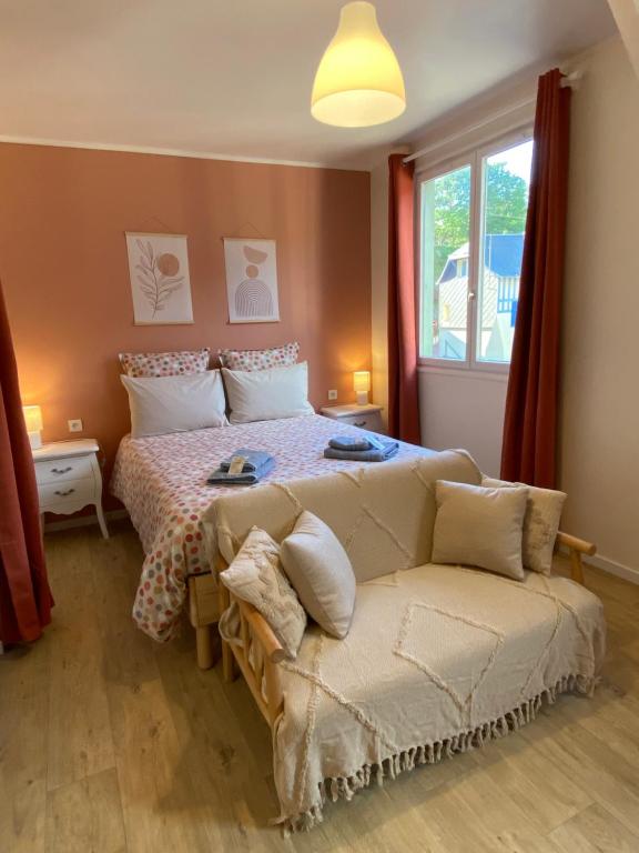 um quarto com uma cama, um sofá e uma janela em Au réconfort de Mers Draps et Serviettes fournies Appartement 12 em Mers-les-Bains