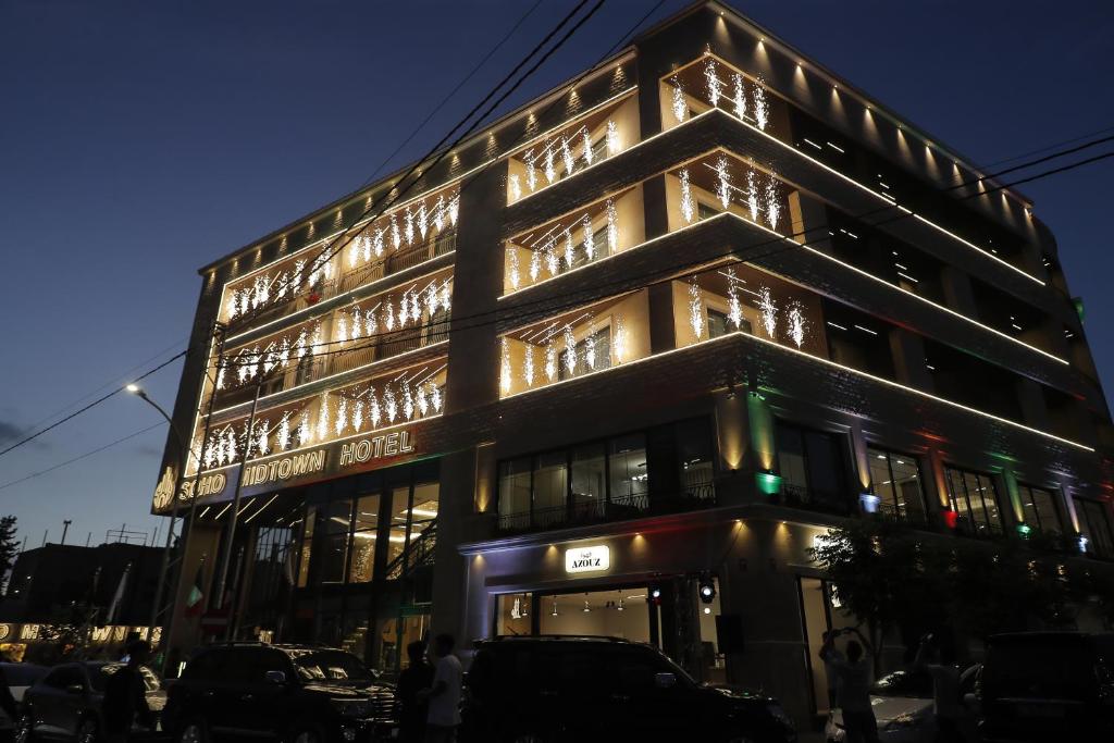 um edifício alto com luzes ao lado em Soho Midtown em Ash Shumaysānī