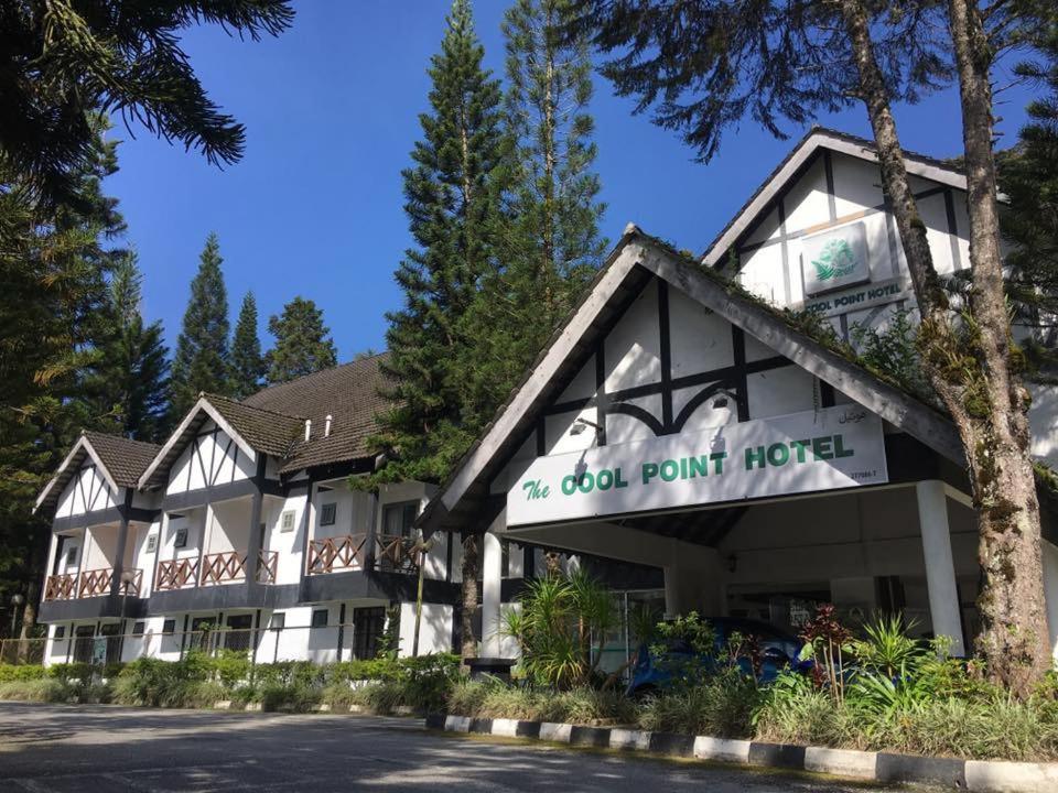 a building with a sign for a dog point hotel at Cool Point Hotel in Tanah Rata