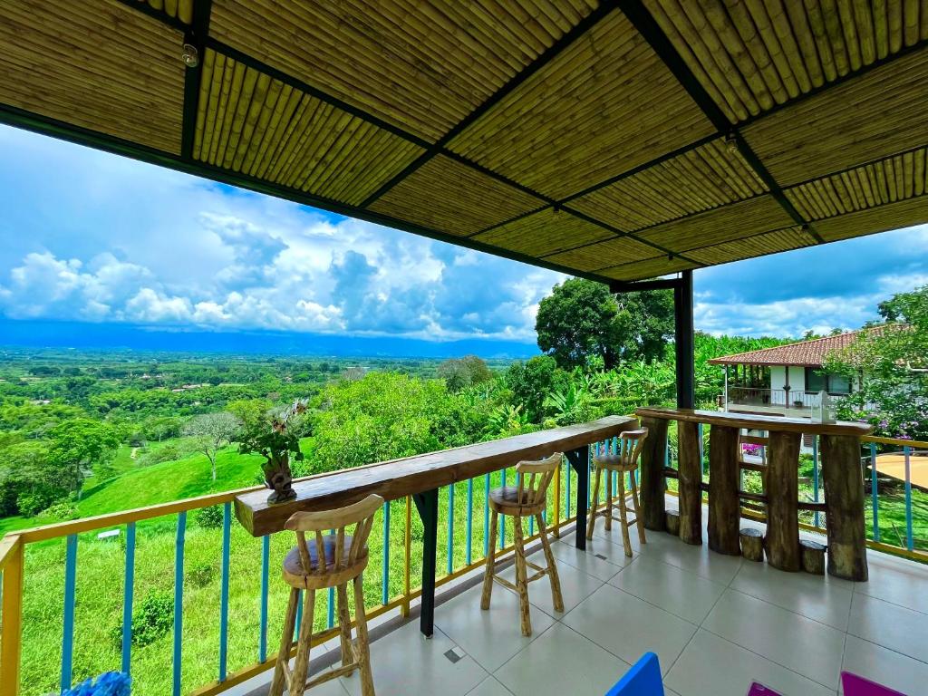 Un balcón con sillas y vistas al océano. en Finca Hotel Mirador La Casona Quindio-Eje Cafetero, en Pueblo Tapado