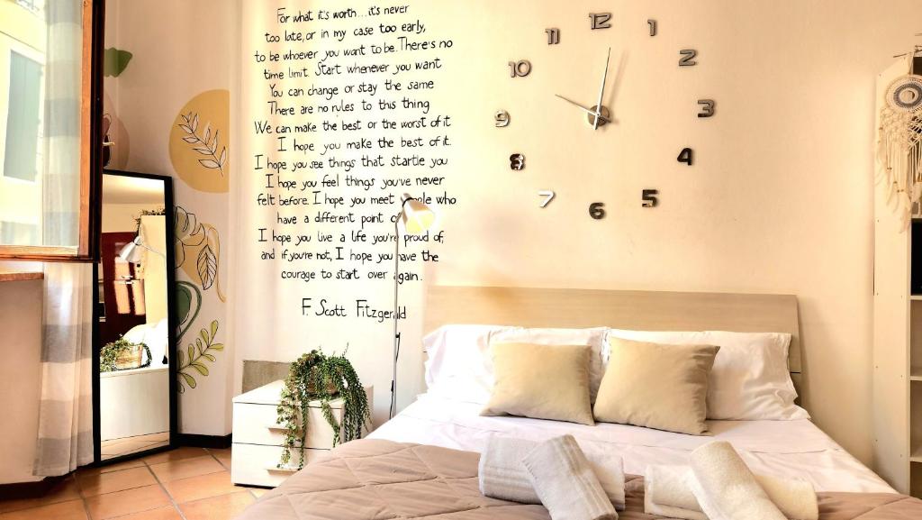 een slaapkamer met een bed en een klok aan de muur bij SanZenoHome StayInVerona Full Apartment in Verona