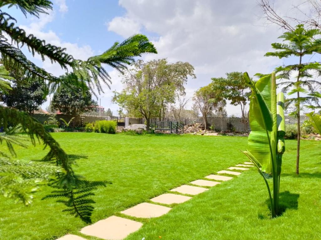 a garden with a pathway in the grass at TROTTERS B&B KENOL in Gitura