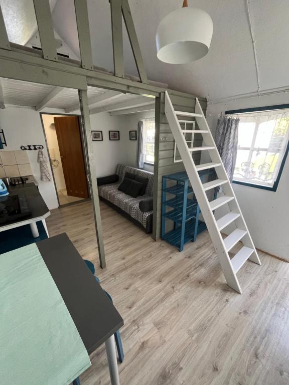 a room with a loft bed and a living room at Domek Rybaka in Gąski