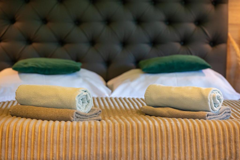 two beds with green and white pillows on them at Malinowa Dolina in Wisła