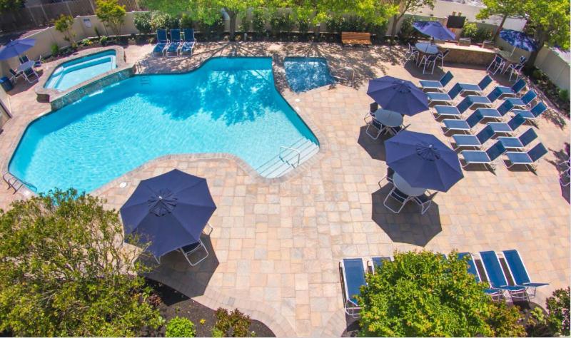 een uitzicht over een zwembad met stoelen en parasols bij Beachcomber Resort in Avalon