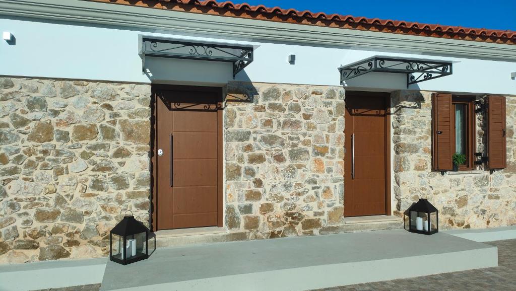 a stone building with brown doors and lights on it at Nafplio Village in Nafplio