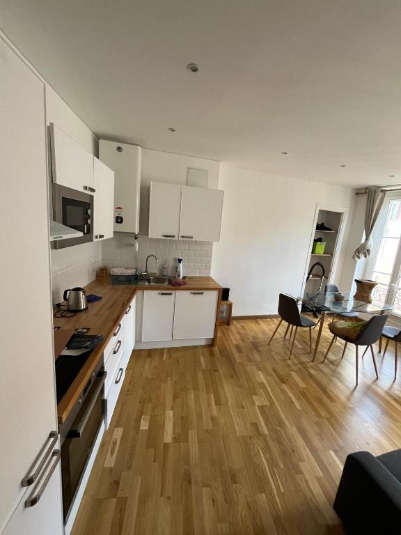 une cuisine avec des armoires blanches et un plancher en bois dans l'établissement Appartement Nice ville gare Iconic, à Nice