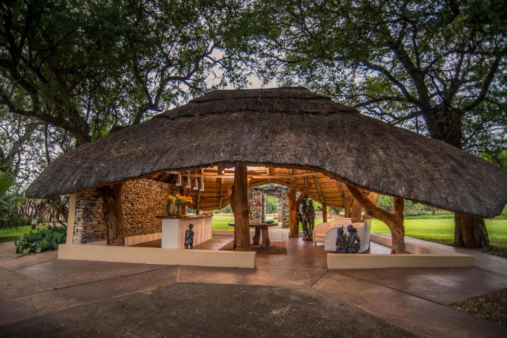 Karongwe Game Reserve的住宿－Karongwe River Lodge，茅草屋顶小屋和桌子