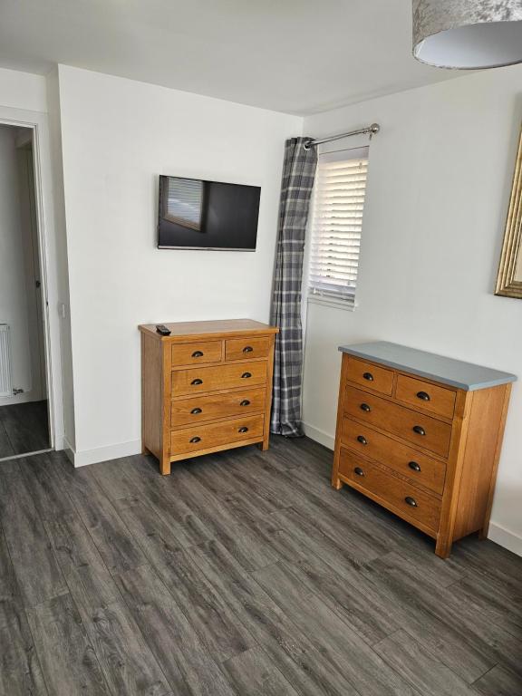 una camera con cassettiera e TV a parete di 5 Fulmar Road**Next to West Beach and Golf Course a Lossiemouth
