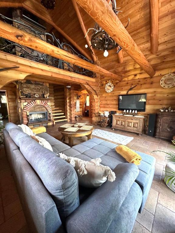 a living room with a blue couch and a tv at Cedrowa Villa - Rezydencja nad jeziorem in Ełk
