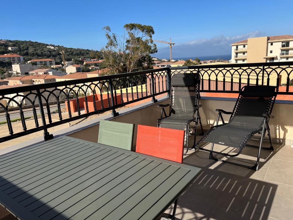 deux chaises et une table sur un balcon avec vue dans l'établissement Grand T2 résidence de standing, à LʼÎle-Rousse