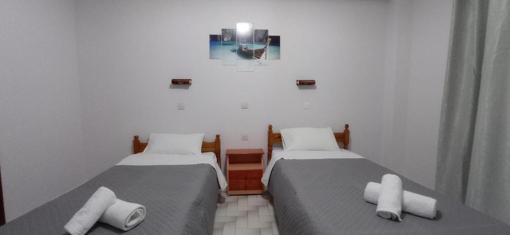 two twin beds in a room with white walls at Hermes in Kavos