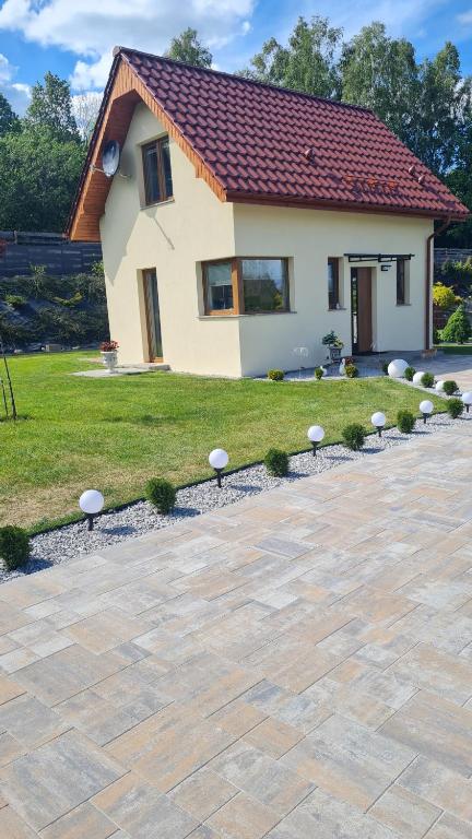a house with a stone patio in front of a yard at Mała Izerka in Mirsk