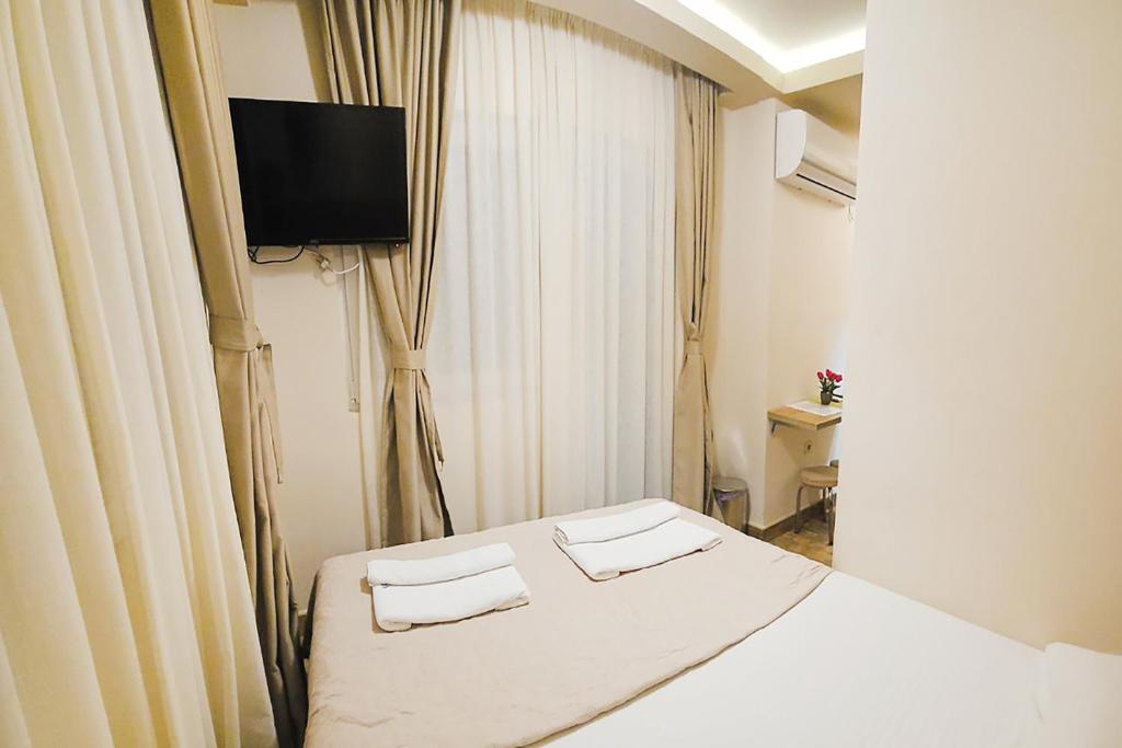a hotel room with a bed and a flat screen tv at Villa Montemaris Budva in Budva