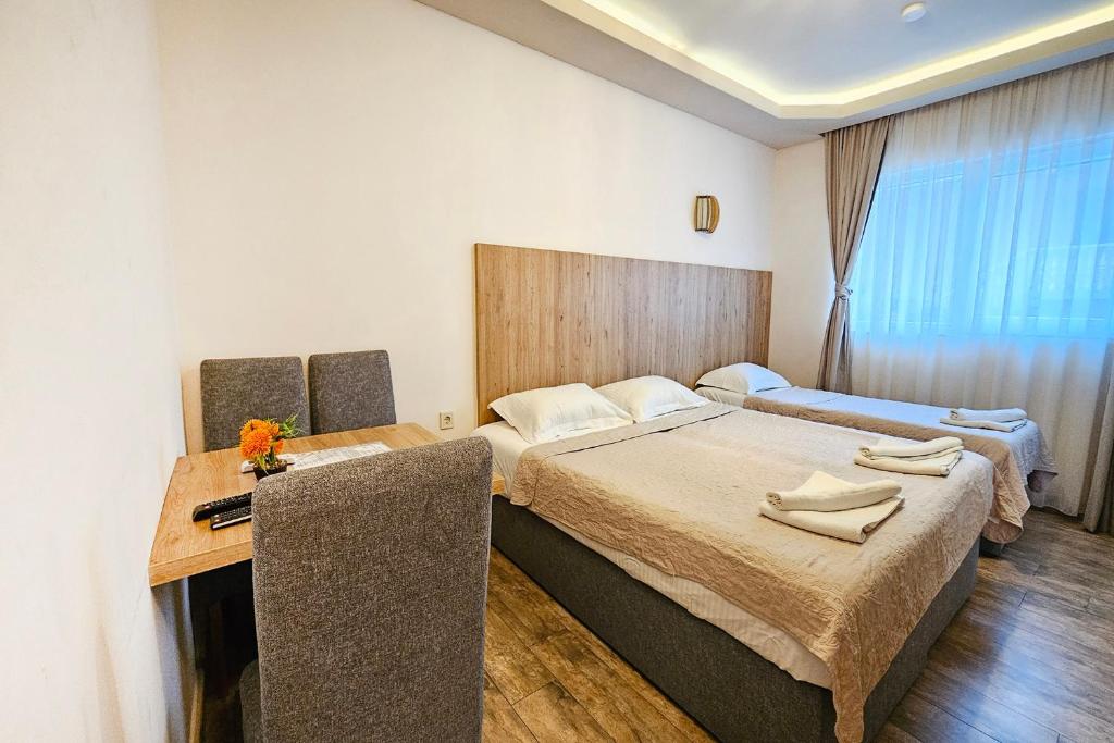a hotel room with two beds and a desk at Villa Montemaris Budva in Budva