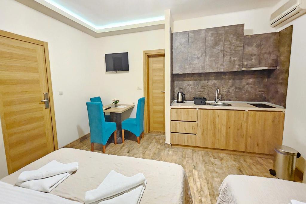 a hotel room with two beds and a kitchen at Villa Montemaris Budva in Budva
