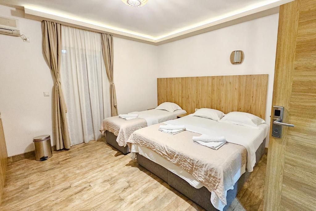 a hotel room with two beds and a window at Villa Montemaris Budva in Budva