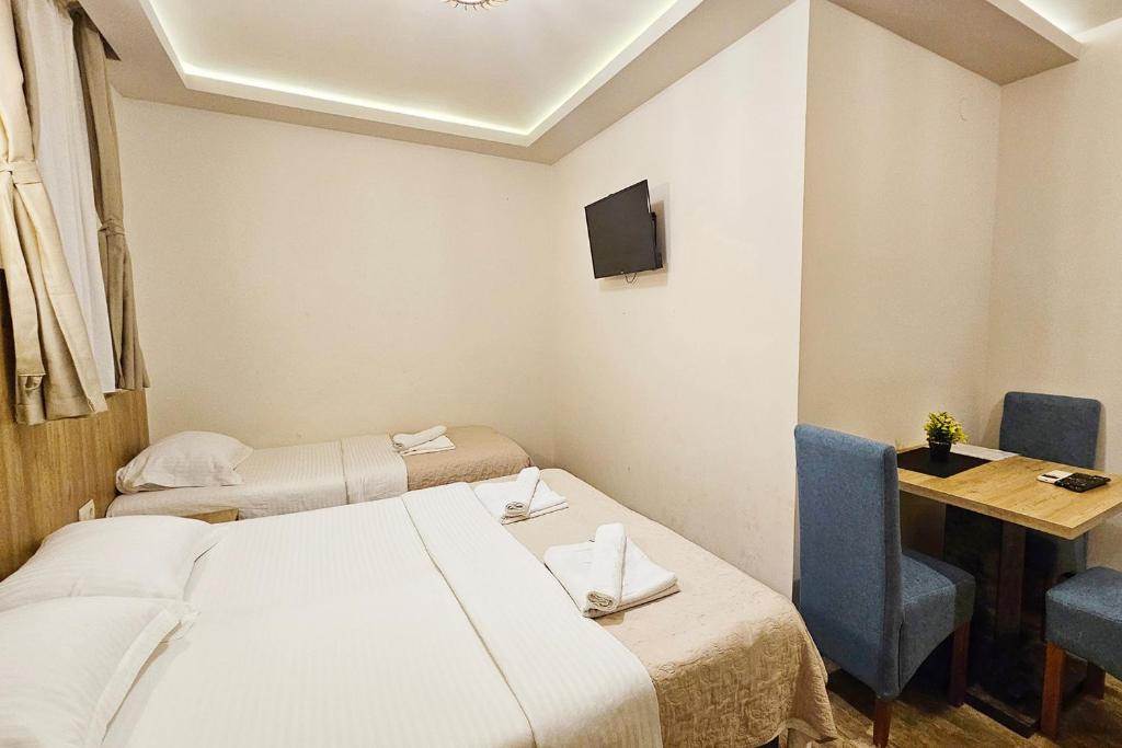 a room with two beds and a table and a television at Villa Montemaris Budva in Budva