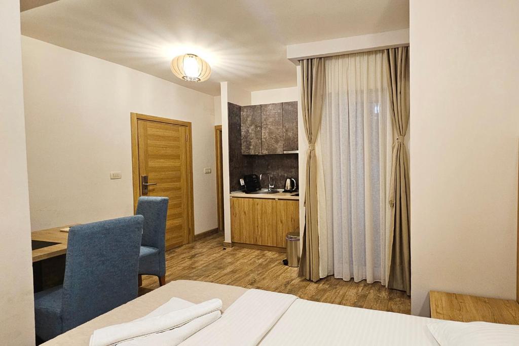 a room with a bed and a desk and a kitchen at Villa Montemaris Budva in Budva