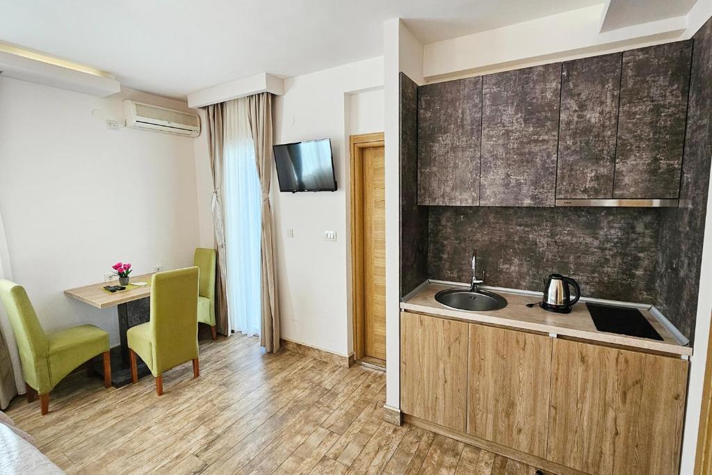 a kitchen with a sink and a table in a room at Villa Montemaris Budva in Budva