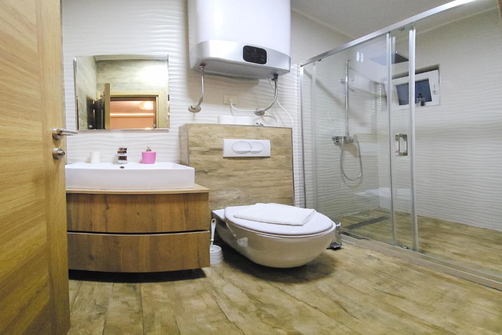 a bathroom with a toilet and a sink and a shower at Villa Montemaris Budva in Budva
