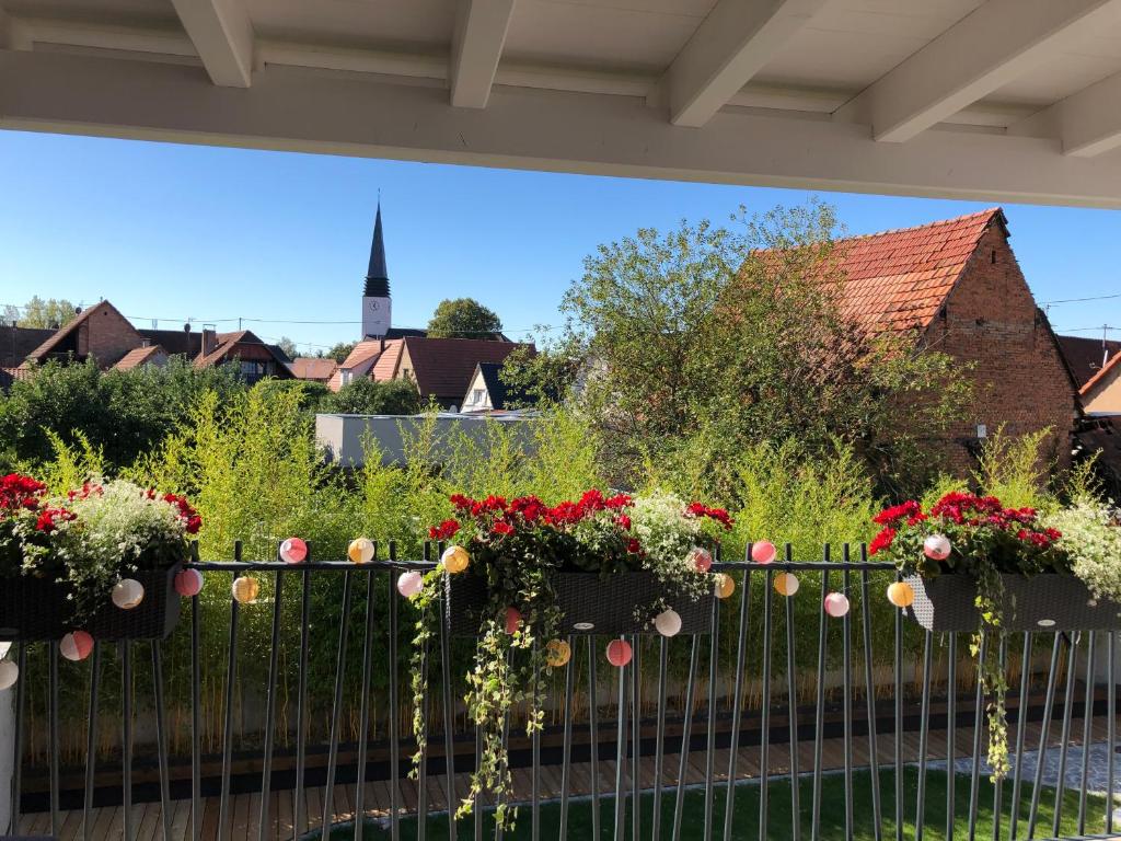 Maison d hotes Coeur de Village Alsace & spa في Rohrwiller: حديقة بها زهور على سياج