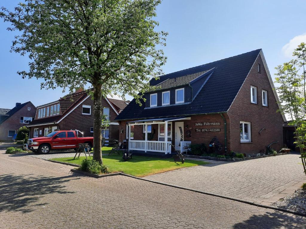 a red truck parked in front of a house at FeWo Fuhrmann in Bensersiel