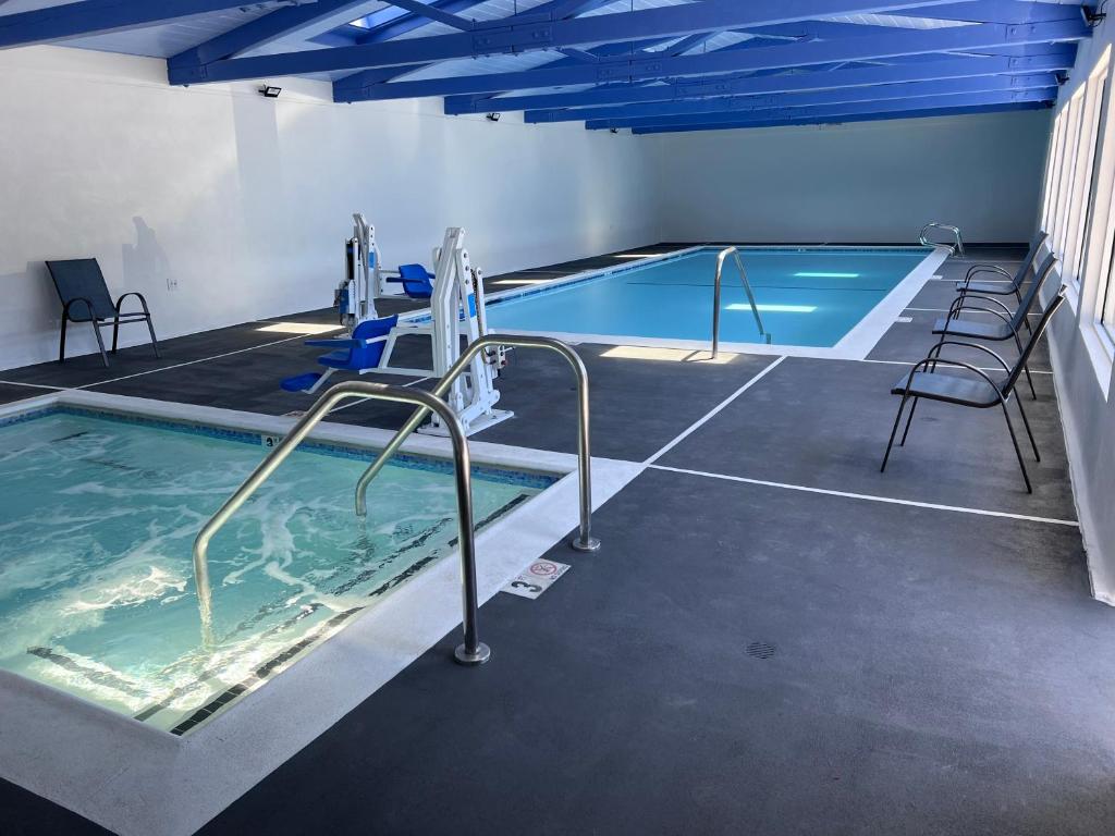uma piscina interior com cadeiras e uma piscina em Surf City Inn & Suites em Santa Cruz