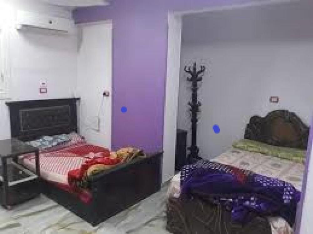 1 dormitorio con paredes de color púrpura, 1 cama y 1 mesa en fort House en Amán