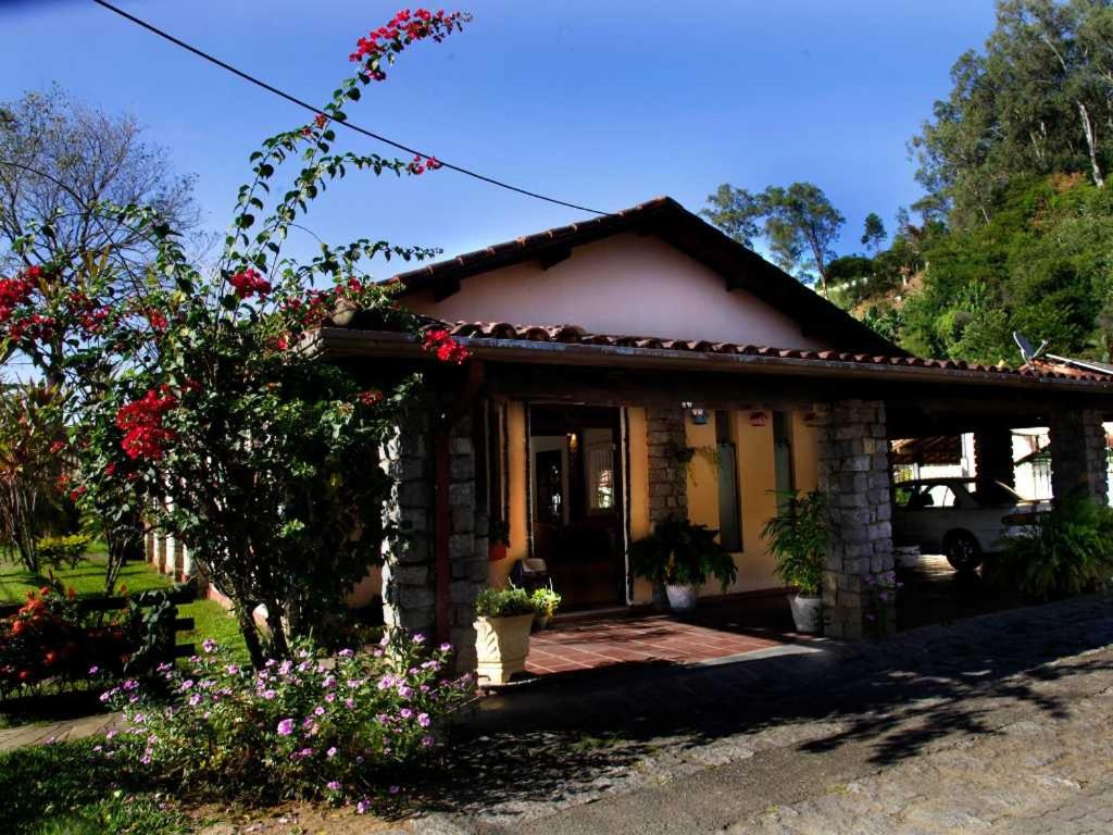 a small house with flowers in front of it at Vila Francesa Hotel in Penedo