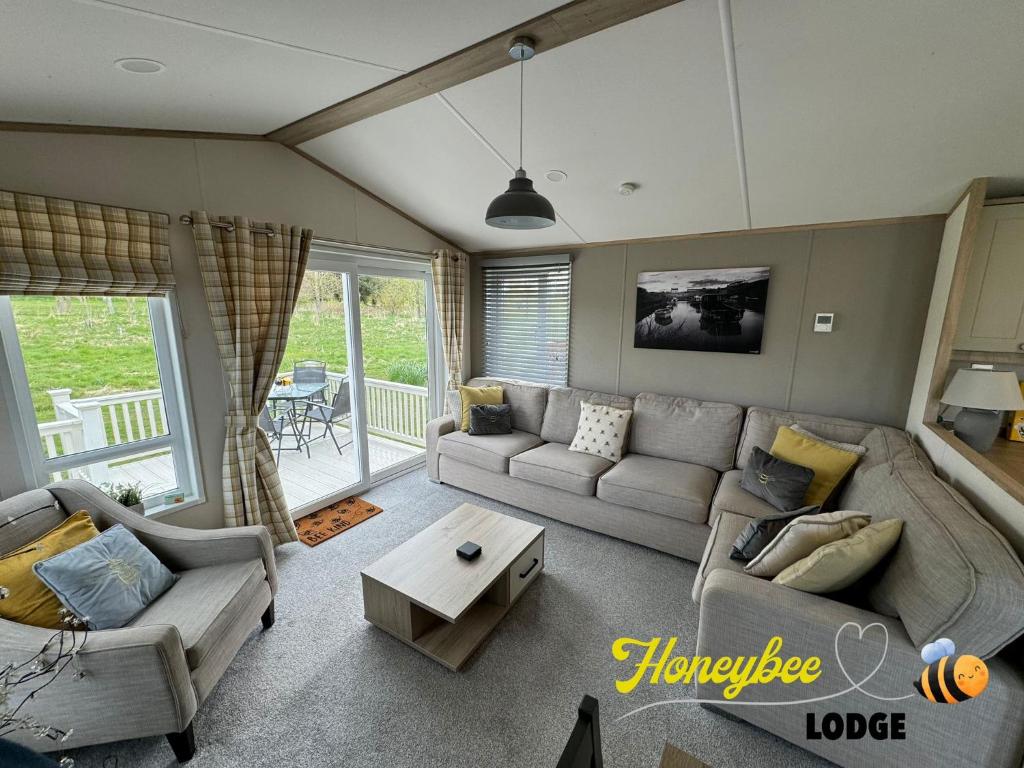 a living room with a couch and a table at Honeybee Lodge in Morpeth