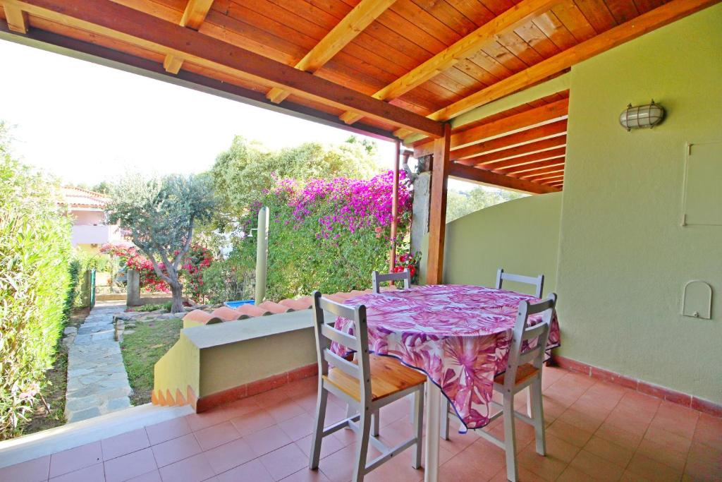 un patio con mesa y sillas en un porche en Bilo Blu Holiday a 80 metri dal mare, en Costa Rei