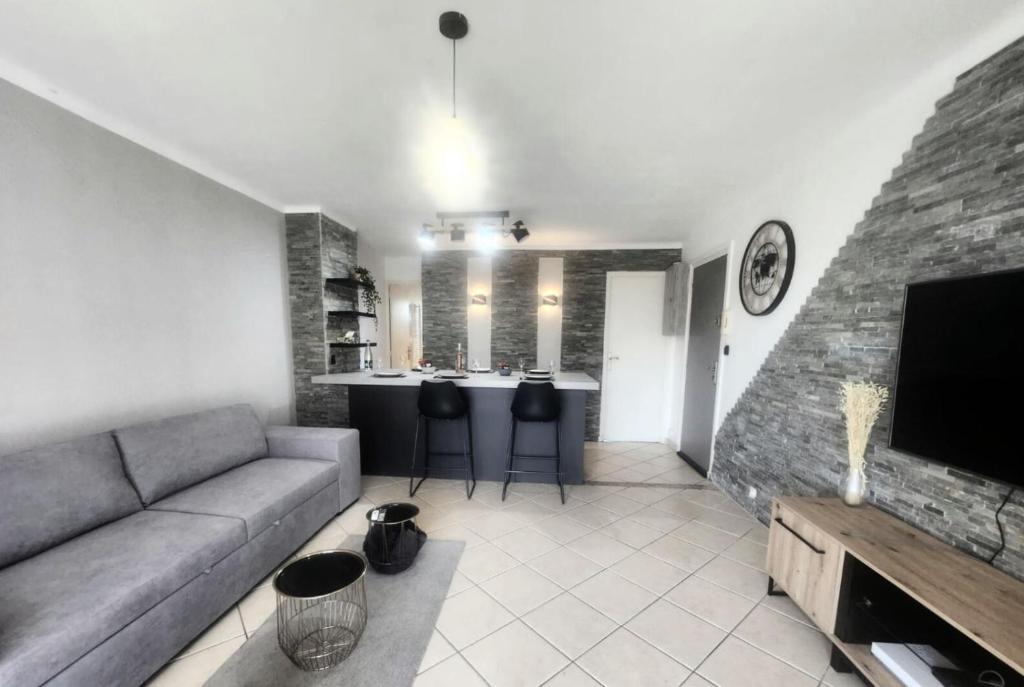 un salon avec un canapé et une table avec des chaises dans l'établissement Aiglon YourHostHelper, à Saint-Raphaël