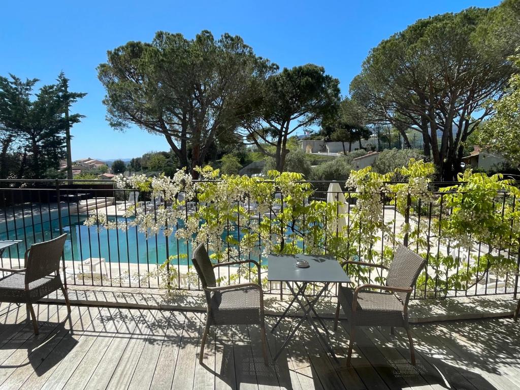 una mesa y sillas frente a un jardín en Auberge du Redier en Colomars