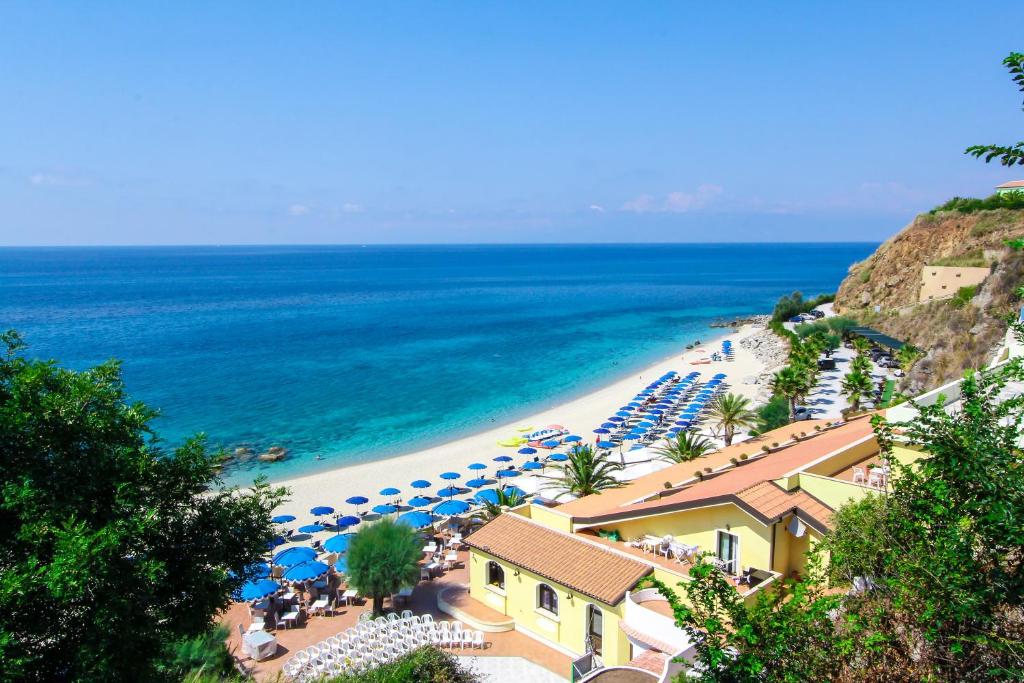 una playa con sombrillas y sillas y el océano en Villaggio Hotel Lido San Giuseppe, en Briatico