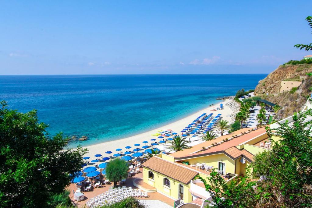 ein Strand mit Sonnenschirmen und Stühlen und das Meer in der Unterkunft Villaggio Hotel Lido San Giuseppe in Briatico