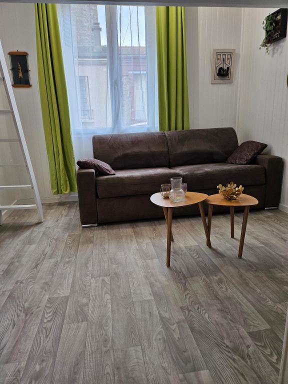 ein Wohnzimmer mit einem Sofa und 2 Tischen in der Unterkunft appartement calme à 10mn à pied de la villette in Le Pré-Saint-Gervais