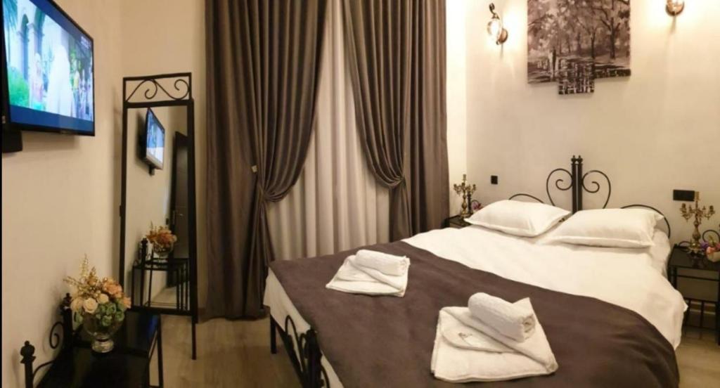 ein Schlafzimmer mit einem Bett mit weißen Handtüchern darauf in der Unterkunft City Center Hotel in Tbilisi City