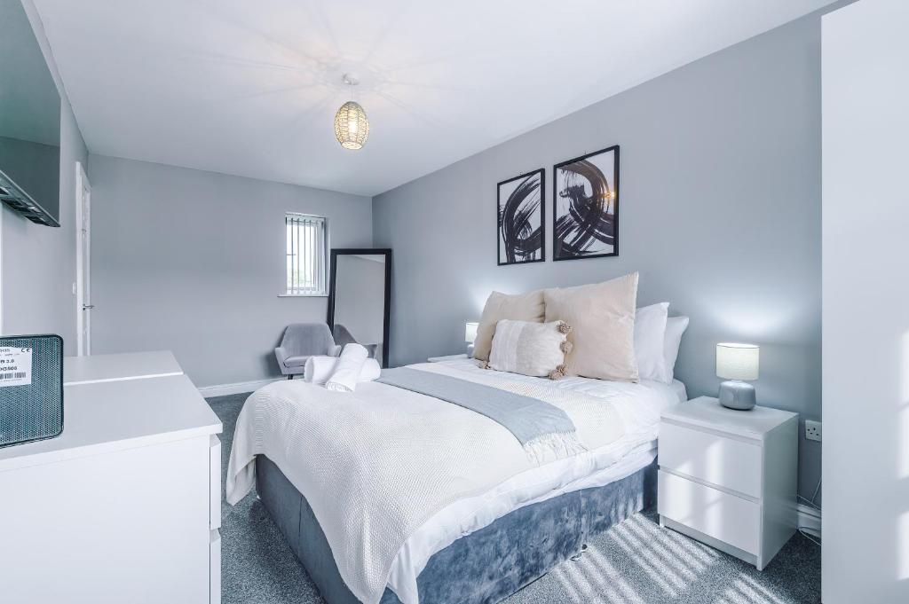 una camera da letto con un grande letto bianco e pareti blu di Lux 3 Bed 10 mins from Centre - Parking & Netflix a Manchester