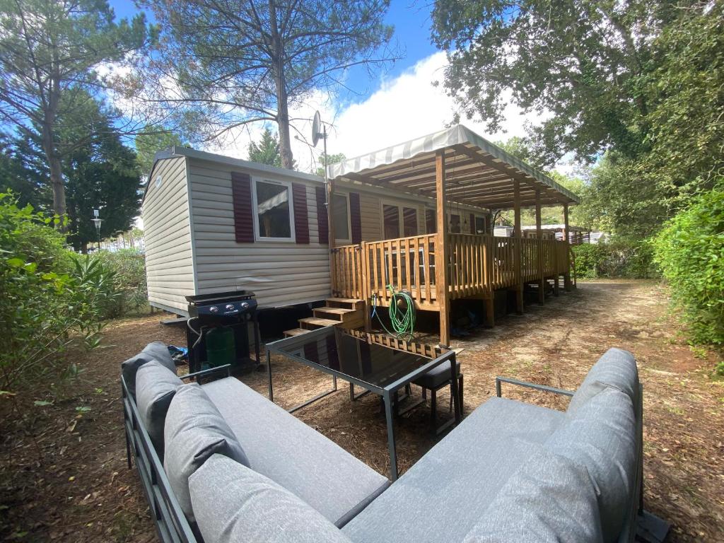 een tiny house met een tafel en een prieel bij Neuf 2022, 6-8 personnes, piscine, vacancesdenani in Saint-Julien-en-Born