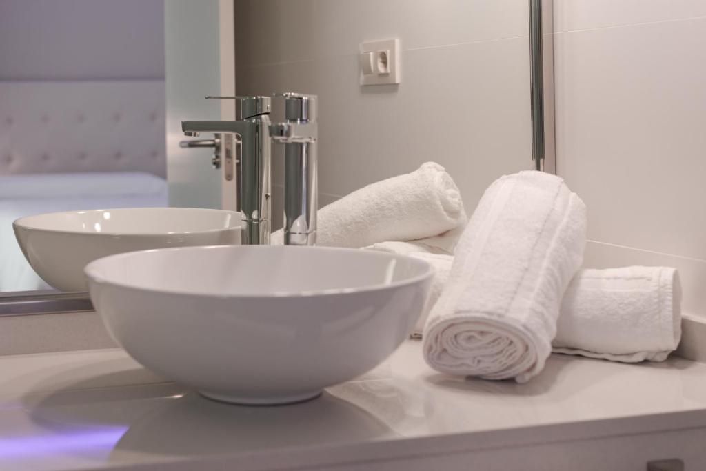 a bathroom with a bowl sink and a mirror at Hotel Jucamar in Cangas de Morrazo
