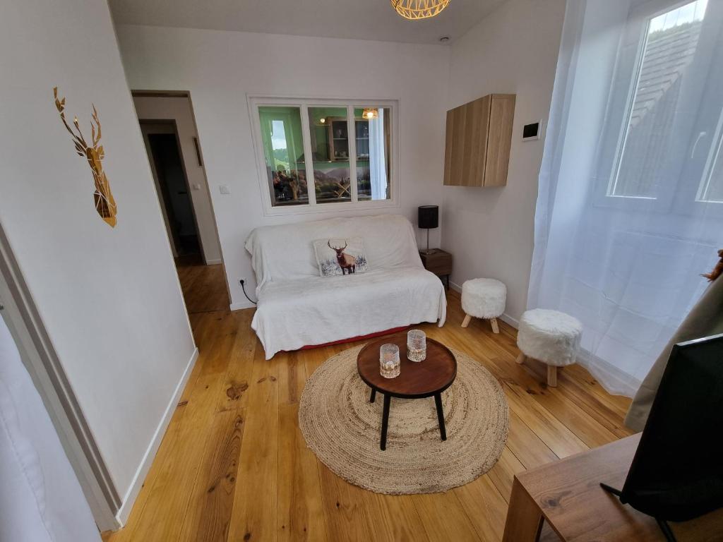 un salon avec un canapé blanc et une table dans l'établissement Les flocons enchantés, neuf, belle vue,4 personnes, à La Bourboule