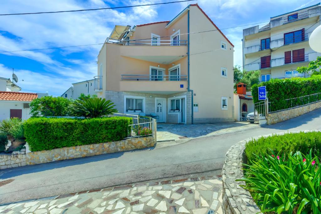 een wit huis met een balkon en struiken bij VILLA JELA in Trogir