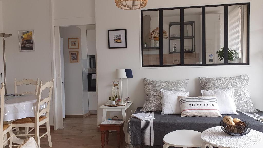 uma sala de estar com uma cama e uma mesa com cadeiras em Le Doux voyage T3, vue Mer, Wi Fi, PARKING gratuit em Toulon